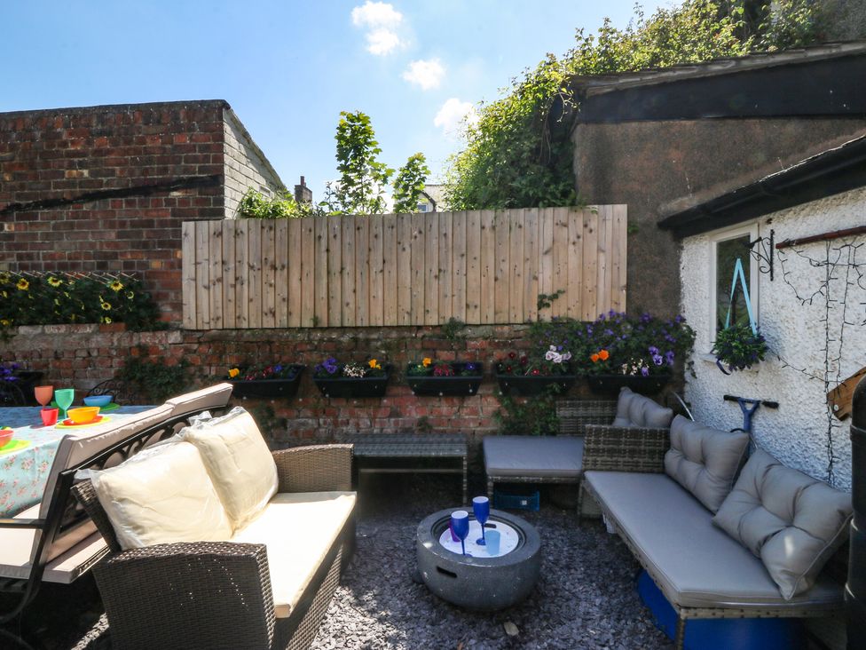 A garden seating area with a table and chairs at Yr Angor (The Anchor) Llandudno Junction