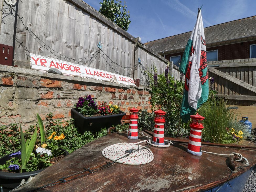A garden with flower pots and a signboard at Yr Angor Llandudno Junction