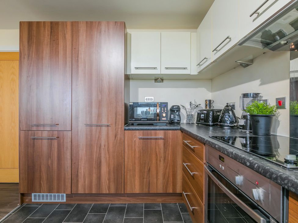 A kitchen with cabinets and appliances at Whitewater Seaview in Newquay