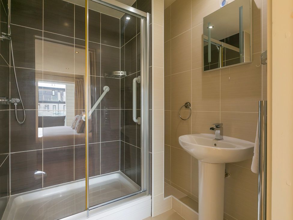 A bathroom with a shower and sink at Whitewater Seaview in Newquay