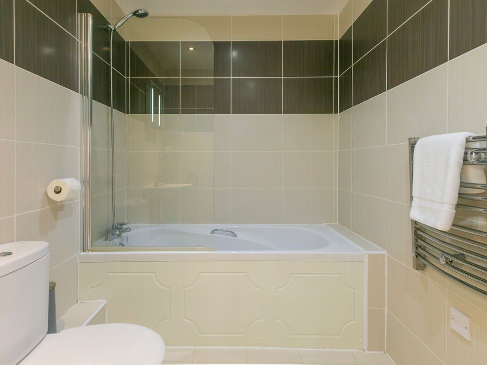 A bathroom with a bathtub and toilet at Whitewater Seaview in Newquay