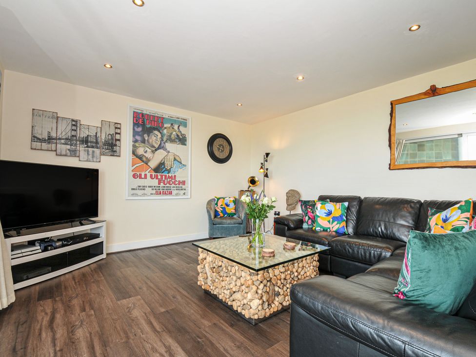 A living room with a sofa and television at Whitewater Seaview in Newquay
