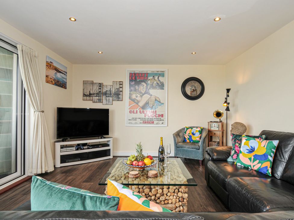 A living room with a television and seating area at Whitewater Seaview in Newquay