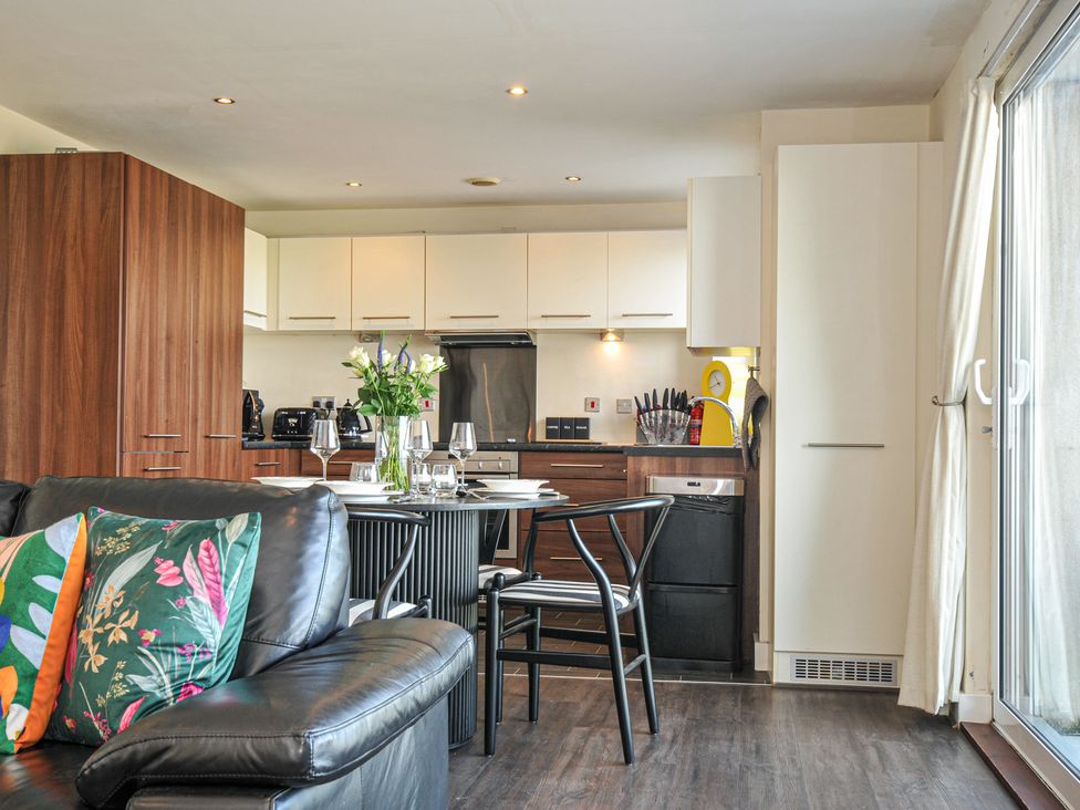 A kitchen with a table and chairs at Whitewater Seaview in Newquay