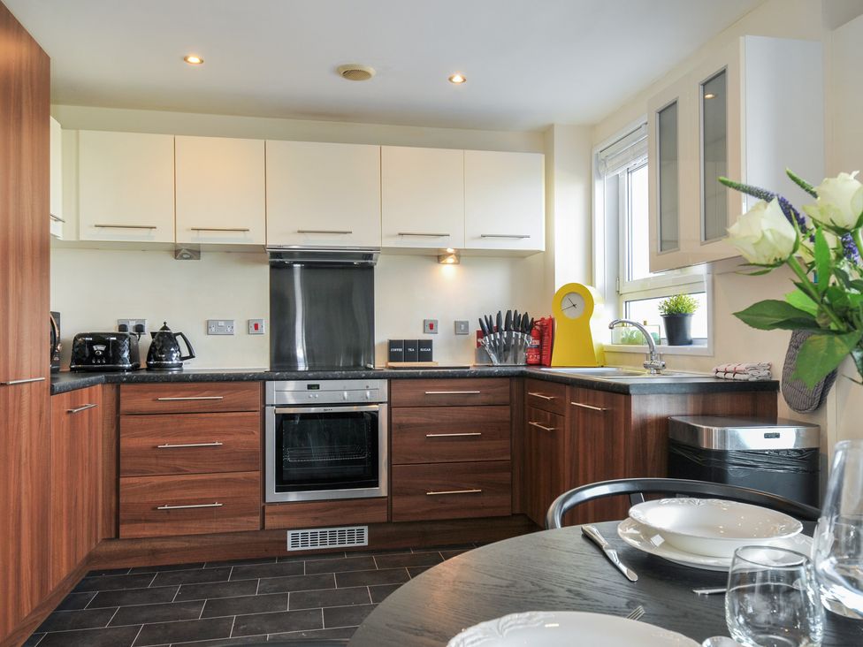 A kitchen with cabinets and appliances at Whitewater Seaview in Newquay