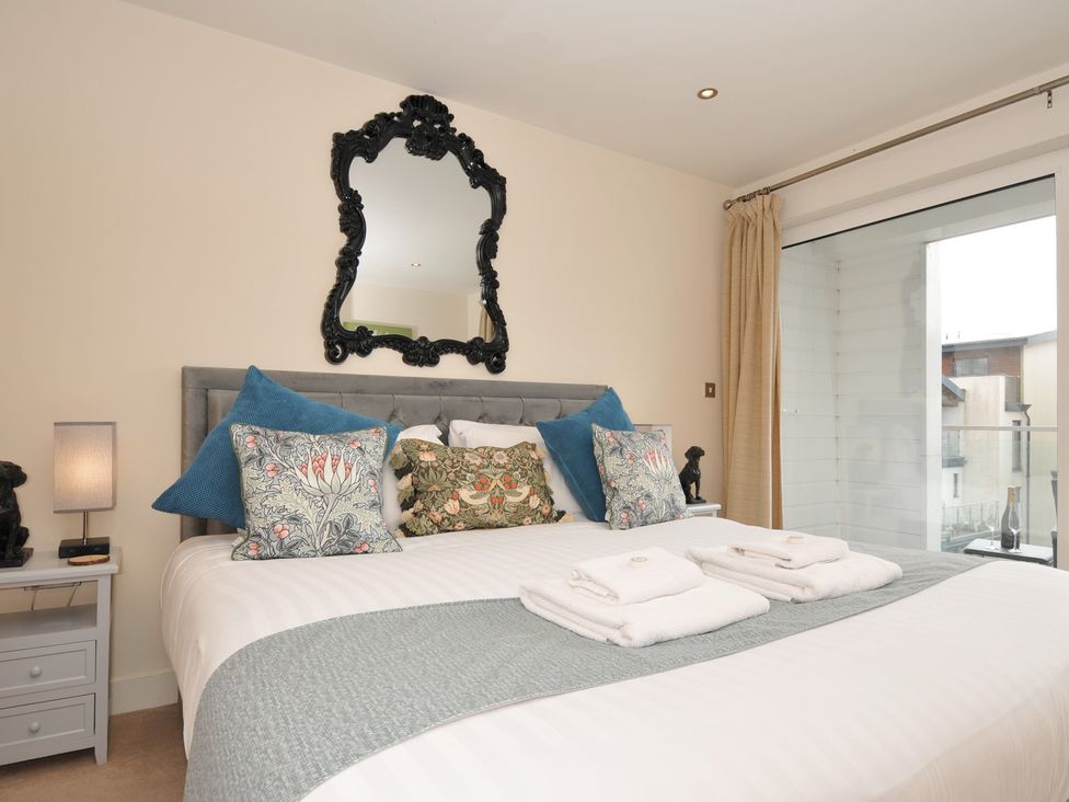 A bedroom with a bed and decorative pillows at Whitewater Seaview in Newquay