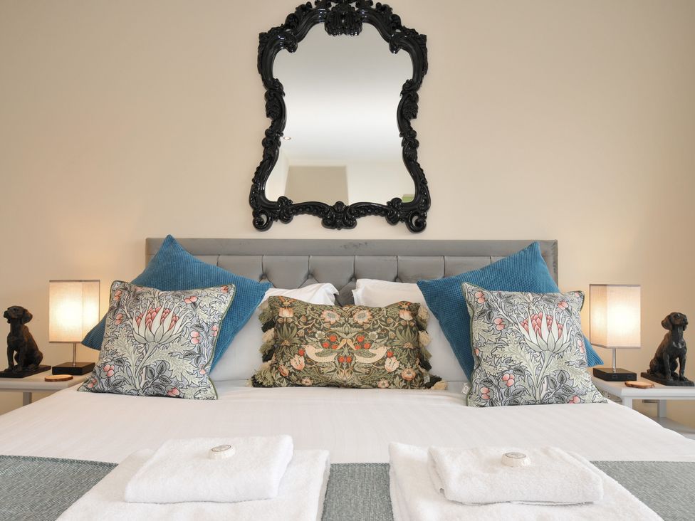 A bedroom with a bed and decorative pillows at Whitewater Seaview in Newquay