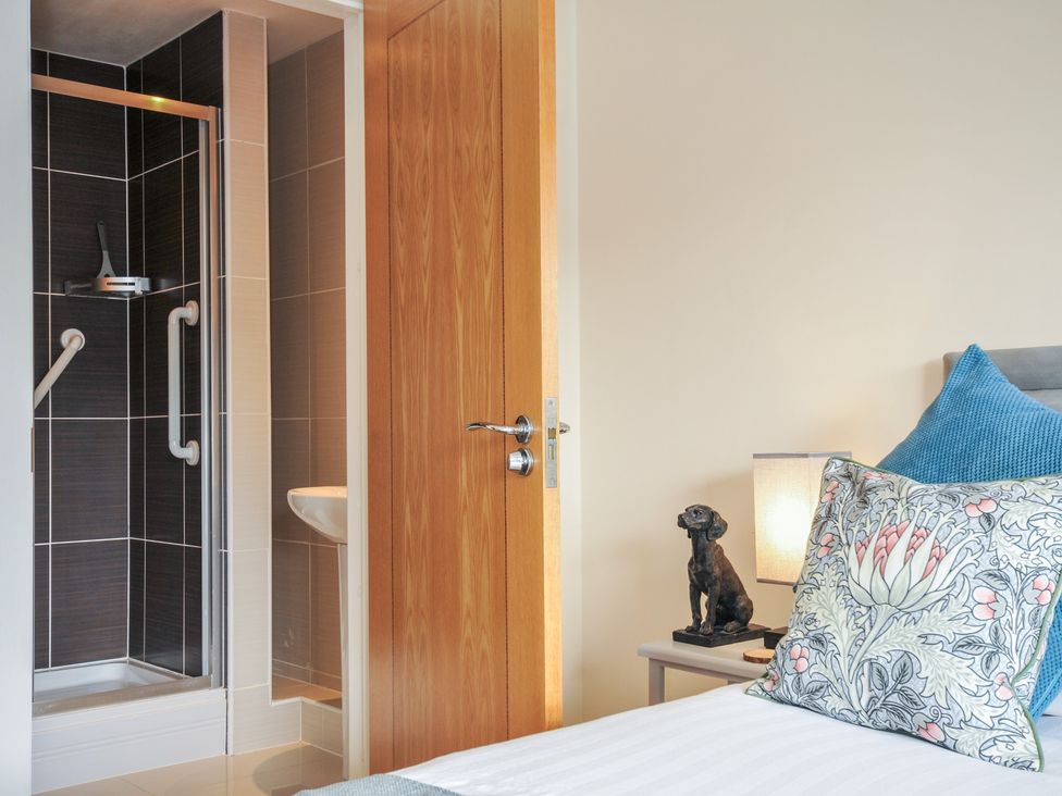 A bathroom with shower and bed at Whitewater Seaview in Newquay
