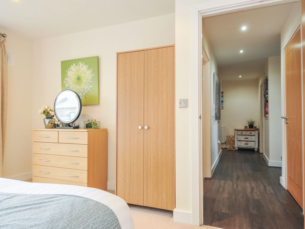 A bedroom with a dresser and mirror at Whitewater Seaview in Newquay