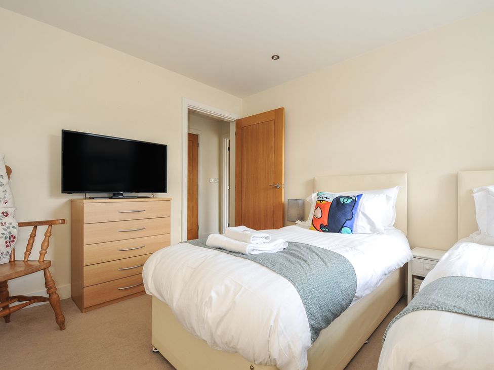 A bedroom with two beds and a television at Whitewater Seaview Newquay