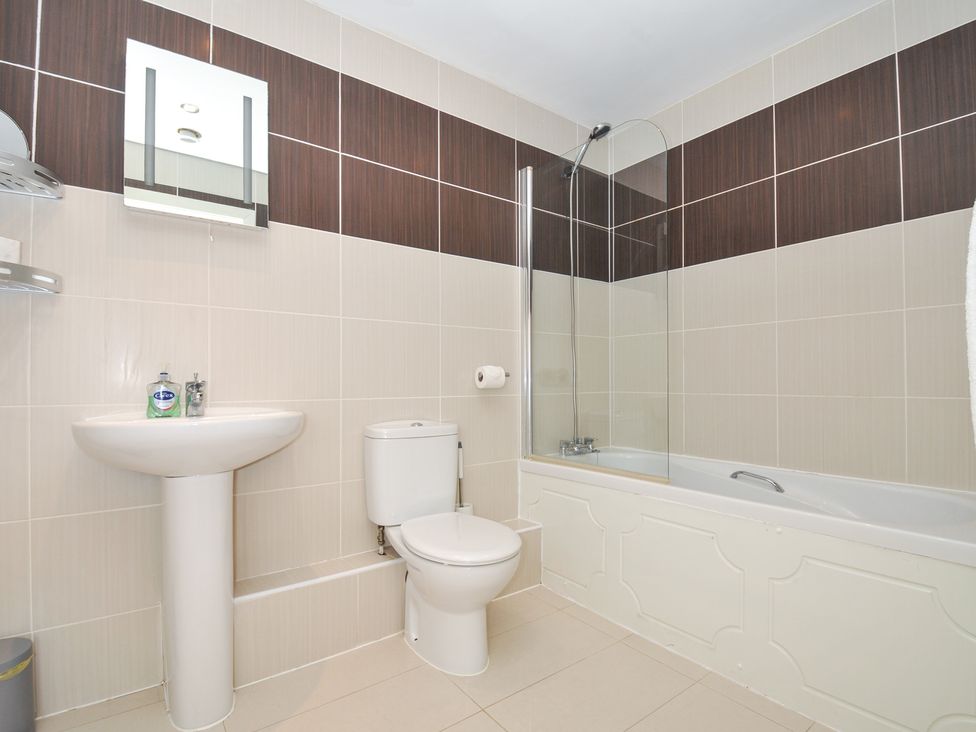 A bathroom with a bath, toilet and sink at Whitewater Seaview in Newquay