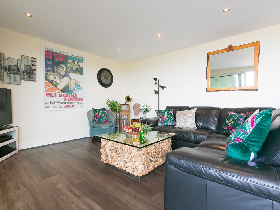 A living room with a sofa and coffee table at Whitewater Seaview in Newquay