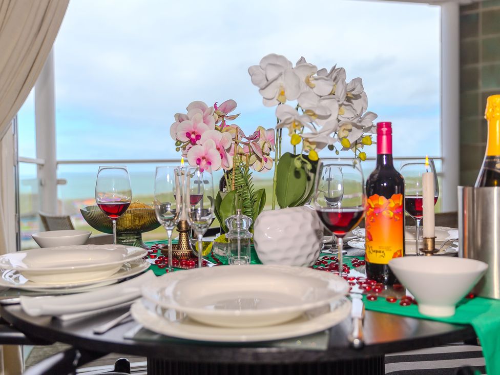 A dining table set with plates and wine glasses at Whitewater Seaview in Newquay
