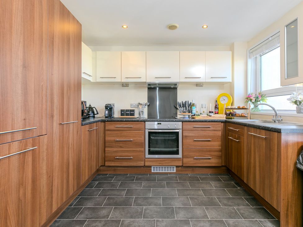A kitchen with cabinetry and appliances at Whitewater Seaview in Newquay