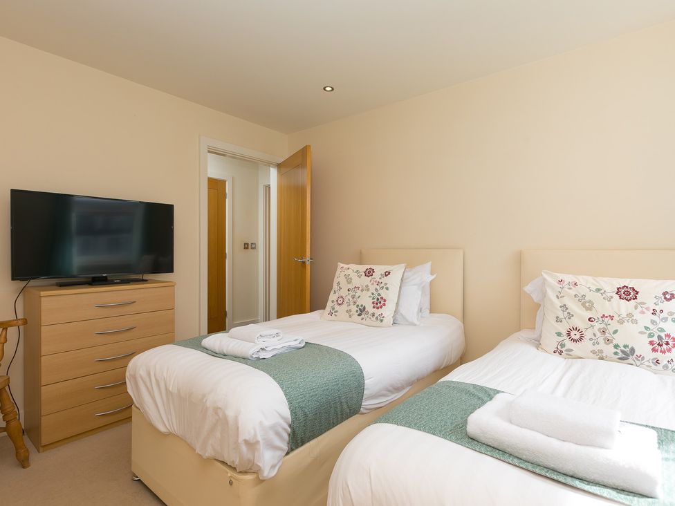 A bedroom with two beds and a television at Whitewater Seaview in Newquay