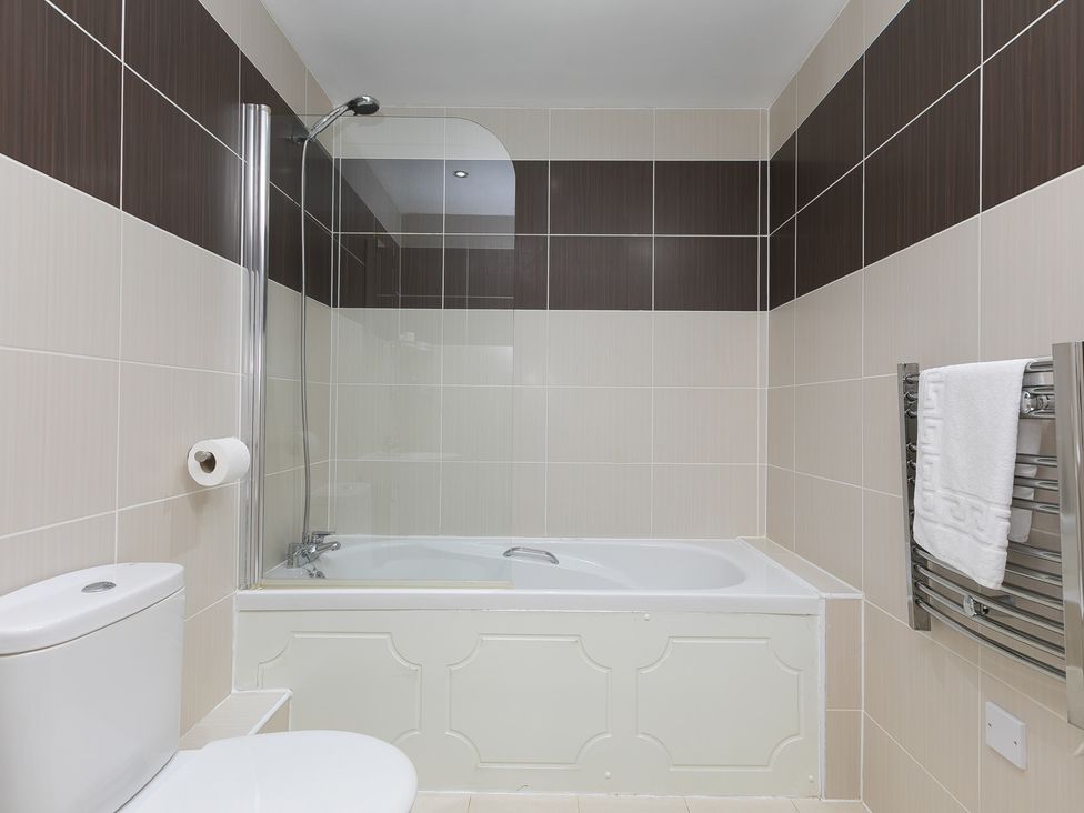 A bathroom with a bathtub and a toilet at Whitewater Seaview in Newquay