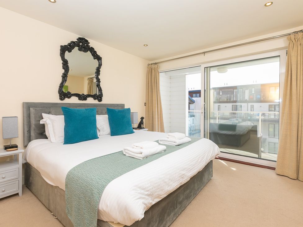 A bedroom with a bed and balcony door at Whitewater Seaview in Newquay