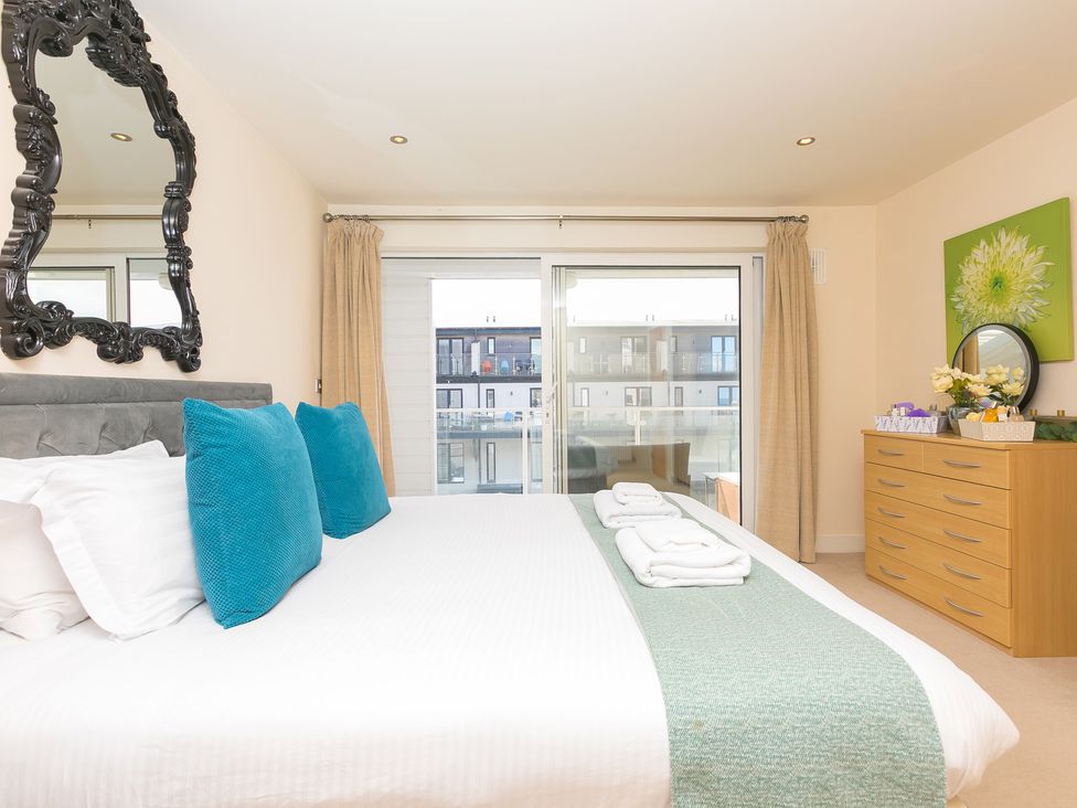 A bedroom with a bed and a dresser at Whitewater Seaview in Newquay