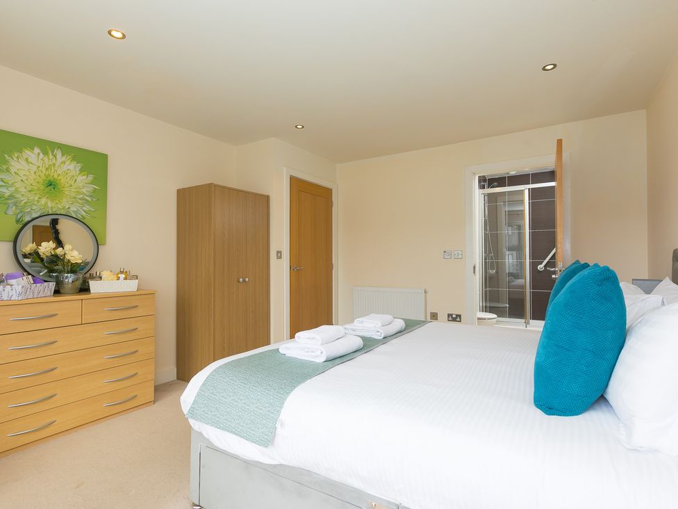 A bedroom with a bed and dresser at Whitewater Seaview in Newquay