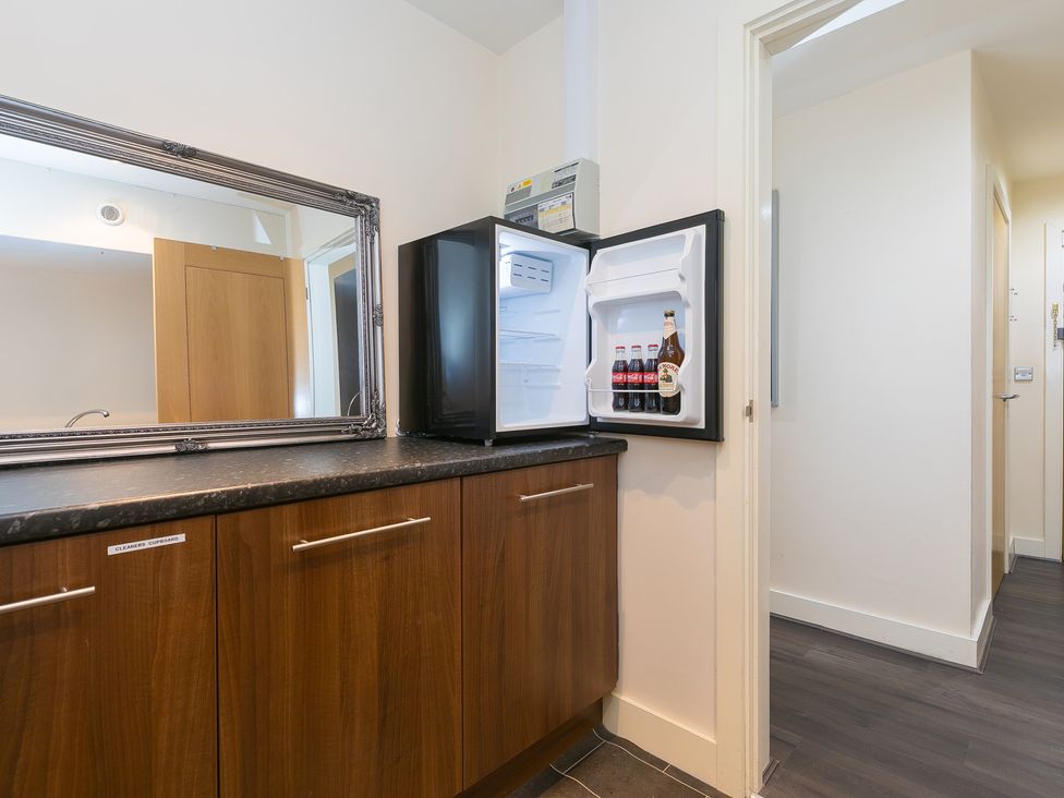 A kitchen with a refrigerator and cabinet at Whitewater Seaview in Newquay