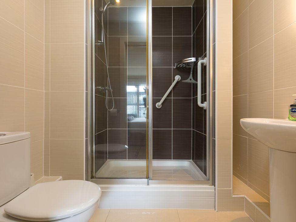 A bathroom featuring a shower, toilet, and sink at Whitewater Seaview in Newquay