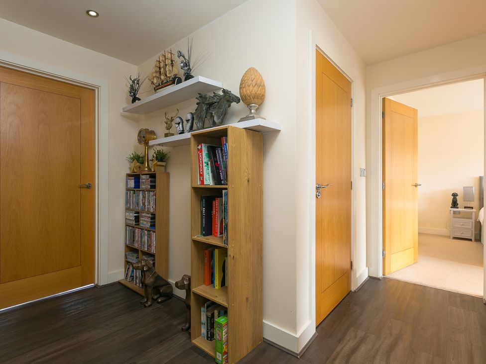 A hallway with a bookcase and decorative items at Whitewater Seaview in Newquay
