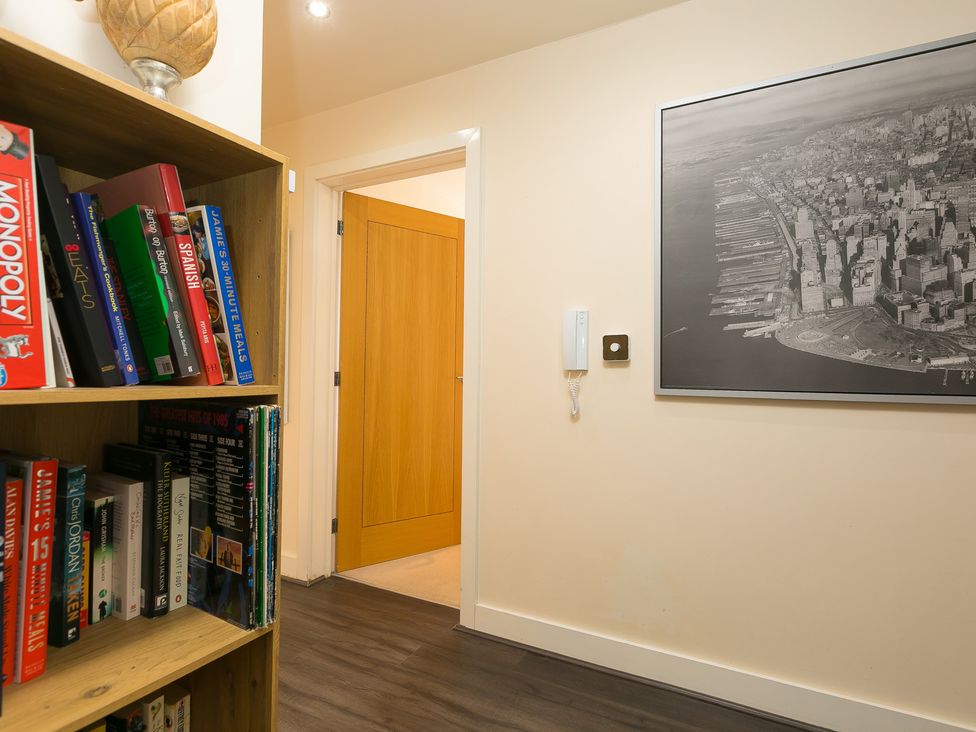 A hallway with a bookshelf and door at Whitewater Seaview in Newquay