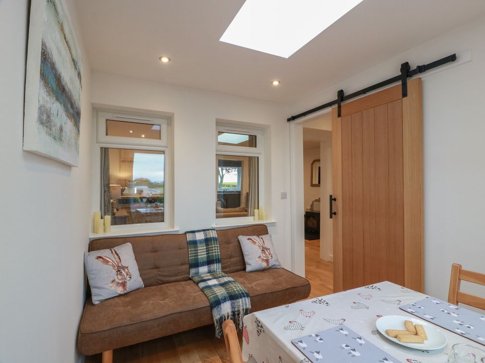 A dining room with a couch and table at Rosalin Cottage Dreghorn near Irvine