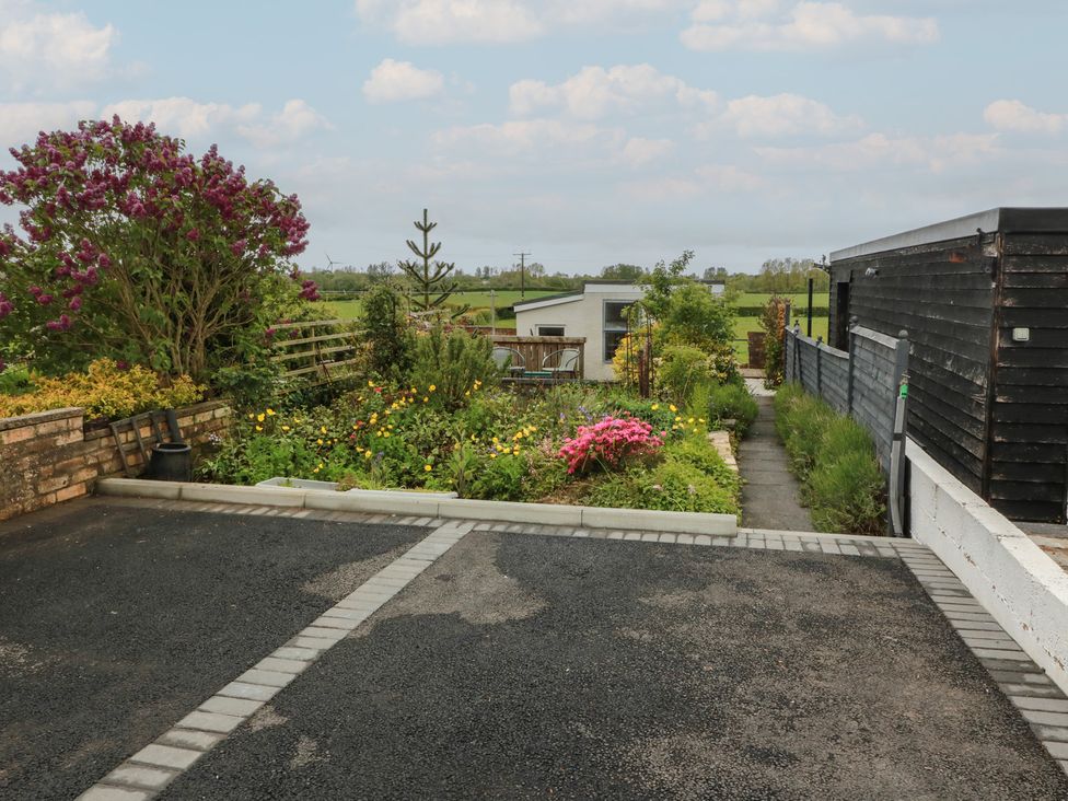 A garden with flowers and a walkway at Rosalin Cottage in Dreghorn near Irvine