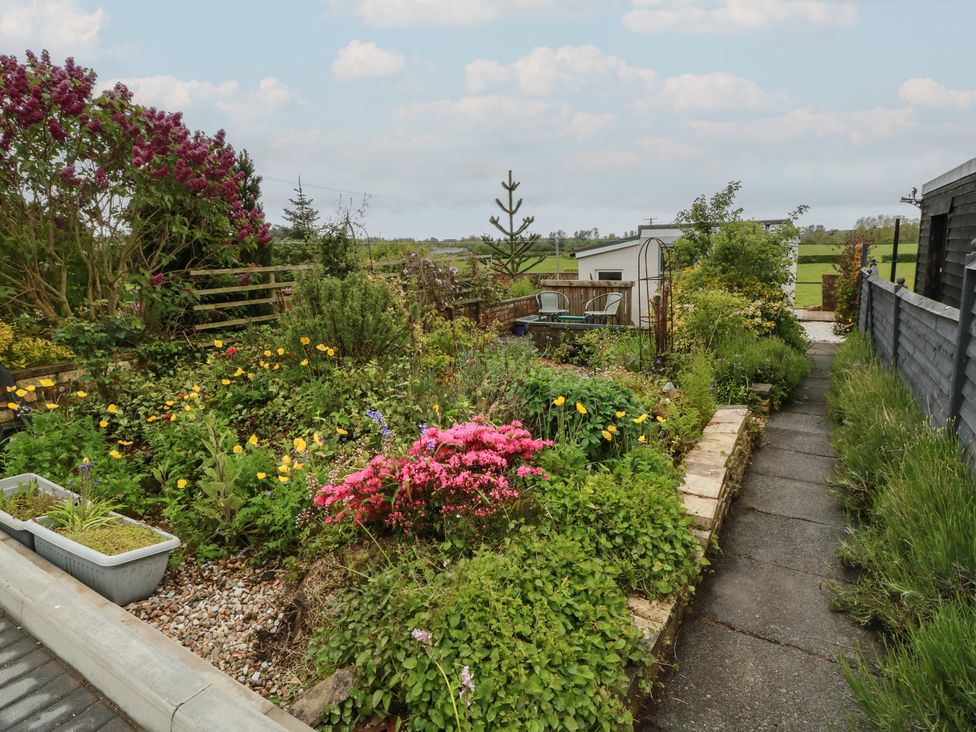 A garden with flowers and a pathway at Rosalin Cottage in Dreghorn near Irvine