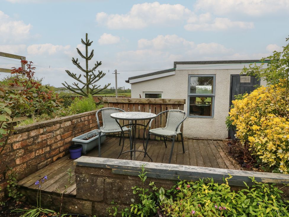 A garden with a table and chairs at Rosalin Cottage in Dreghorn near Irvine