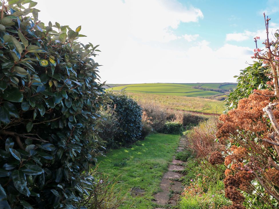 A garden path surrounded by bushes leading to hills at Awalek, Cumber Close Malborough