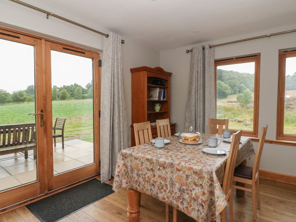 A dining room with a table and chairs at Taffs Barn Fortrose near Rosemarkie
