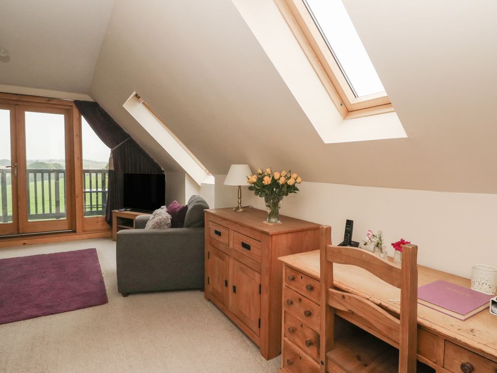 An attic room with a sofa and desk at Taffs Barn Fortrose near Rosemarkie