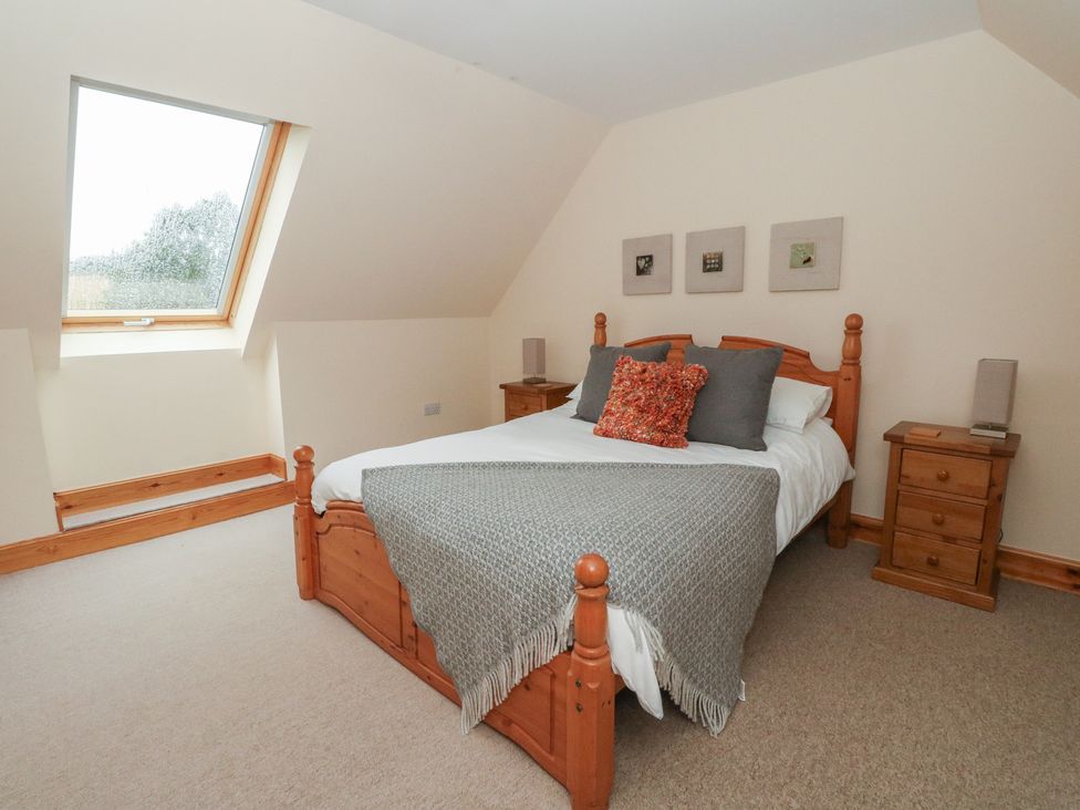 A bedroom with a bed and nightstand at Taffs Barn Fortrose near Rosemarkie