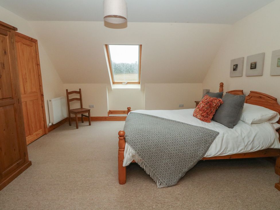 A bedroom with a bed and wardrobe at Taffs Barn Fortrose near Rosemarkie