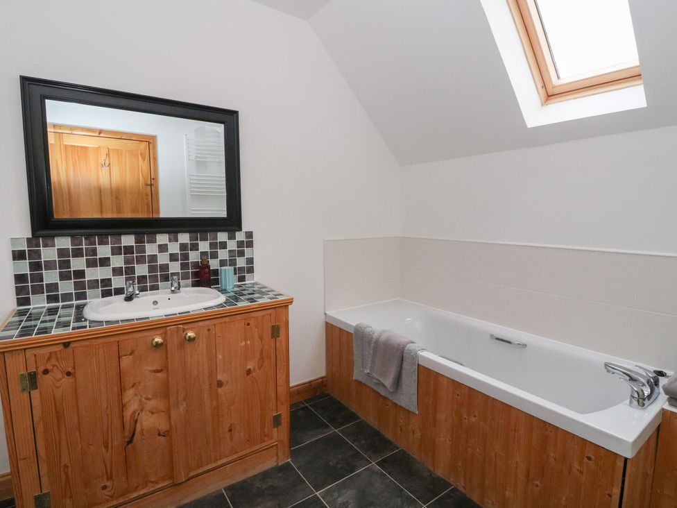 A bathroom with a bathtub and sink at Taffs Barn Fortrose near Rosemarkie