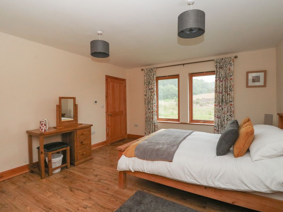 A bedroom with a bed and a dresser at Taffs Barn Fortrose near Rosemarkie