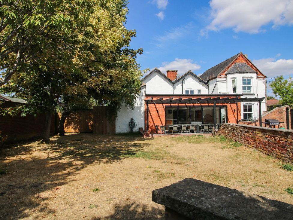 A garden with trees and a house at The Lodge in Shawbury