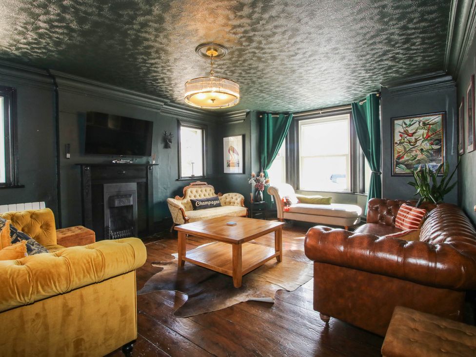 A living room with sofas, a coffee table, and a television at The Lodge in Shawbury