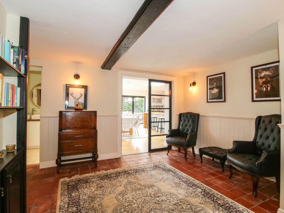 A snug with two armchairs and a bookshelf at The Lodge in Shawbury