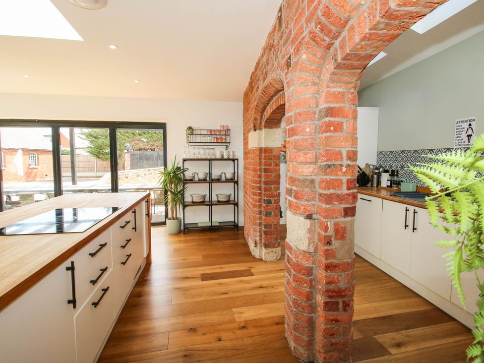A kitchen with a brick arch and a wooden island at The Lodge in Shawbury