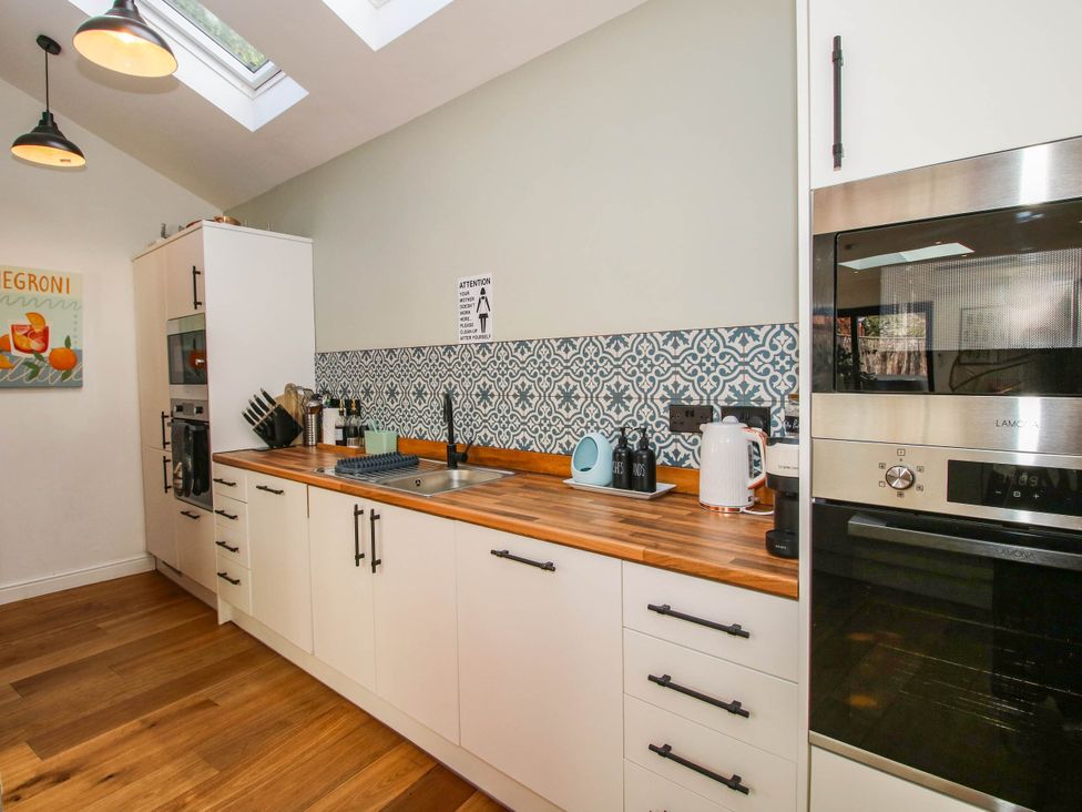 A kitchen with cabinets, oven, sink and utensils at The Lodge in Shawbury
