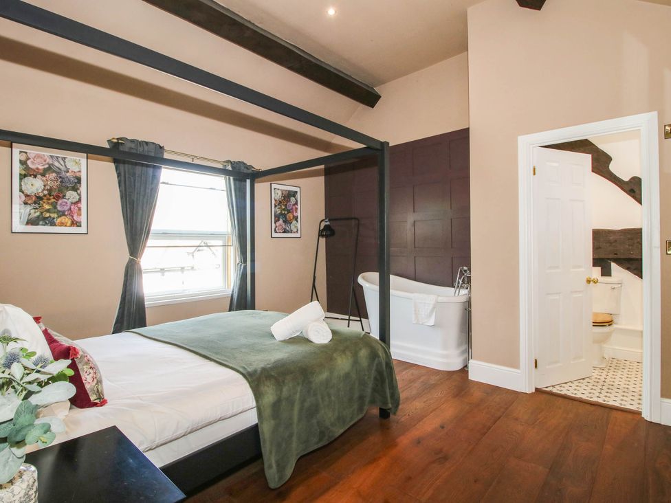 A bedroom with a bed and a bathtub at The Lodge in Shawbury