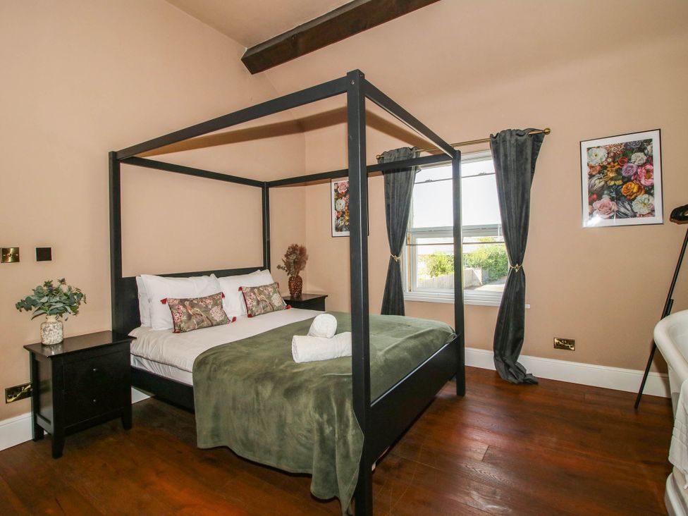 A bedroom with a four-poster bed at The Lodge in Shawbury