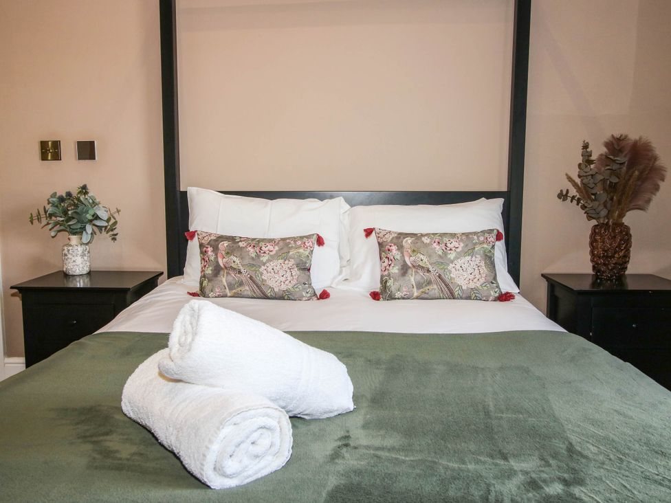 A bedroom with a bed and decorative pillows at The Lodge in Shawbury