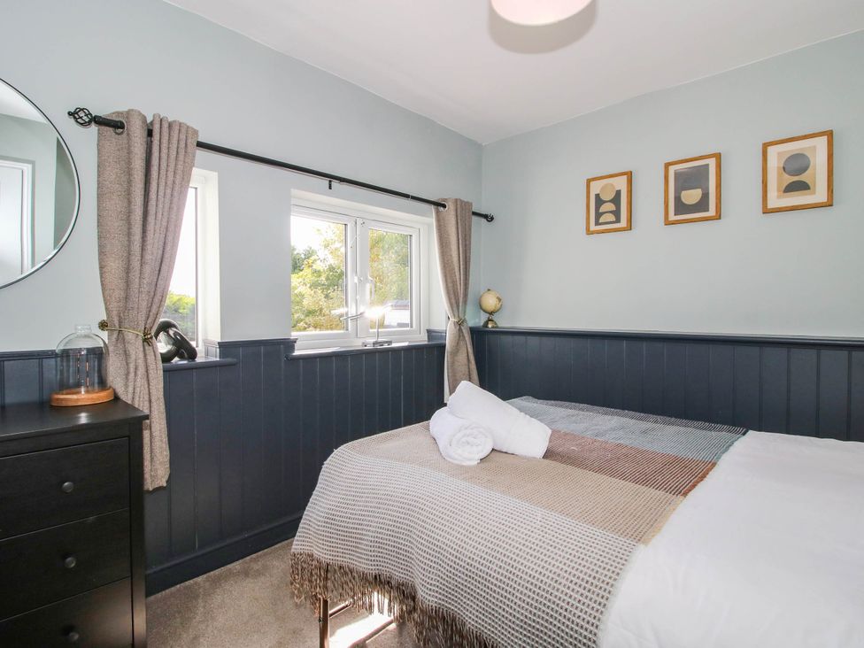 A bedroom with a bed and dresser at The Lodge in Shawbury