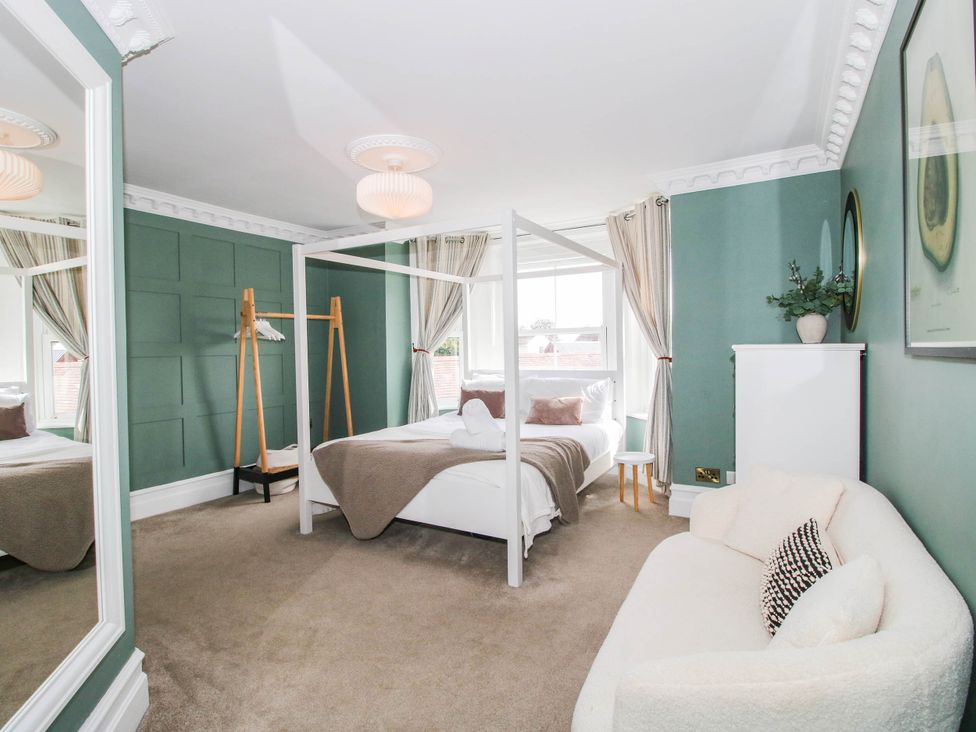 A bedroom with a bed and sofa at The Lodge in Shawbury