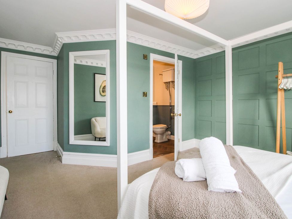 A bedroom with a bed and a mirror at The Lodge in Shawbury
