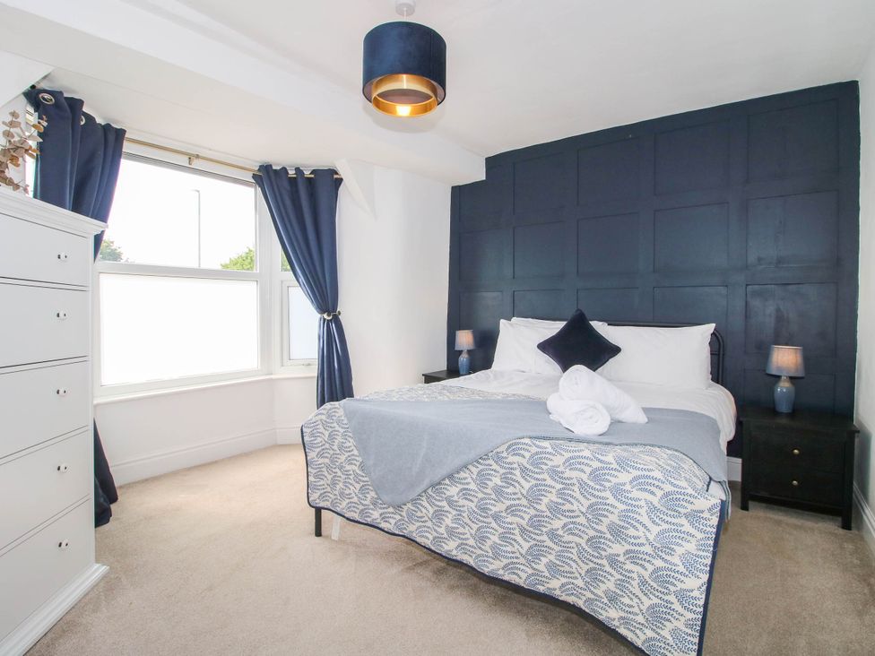 A bedroom with a bed and dresser at The Lodge in Shawbury